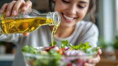 дівчина льє олію в салат